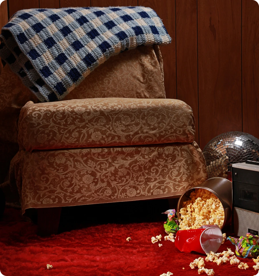 Gemütlicher Sessel auf rotem Teppich mit Popcorn.