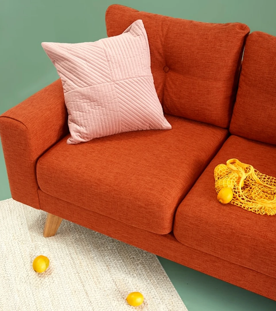 Orangefarbenes Sofa mit Kissen und Deko